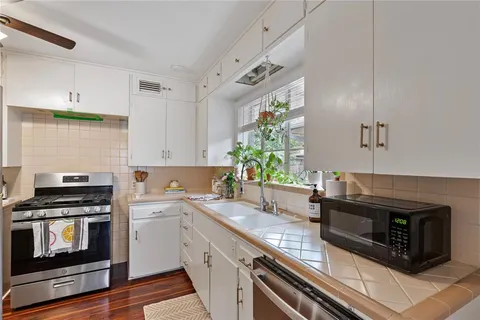 a kitchen with granite countertop a stove and a sink