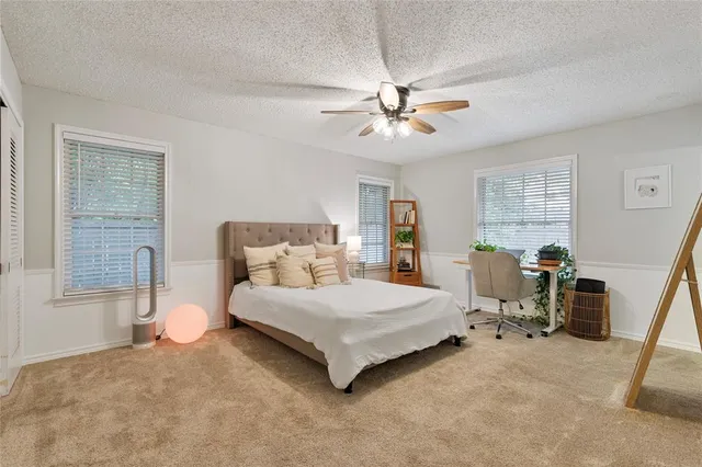 a bedroom with a bed chandelier and a window