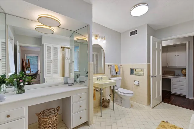 a spacious bathroom with a double vanity sink toilet and a mirror