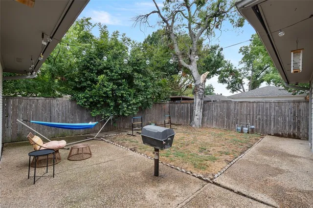a view of a chairs and table in backyard