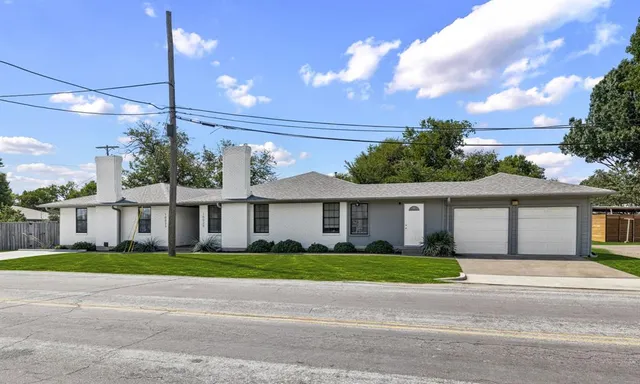 a front view of a house with a garden and plants
