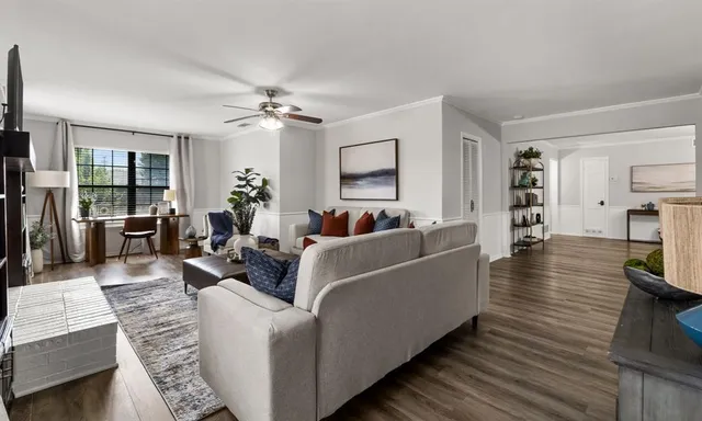 a living room with furniture and a wooden floor