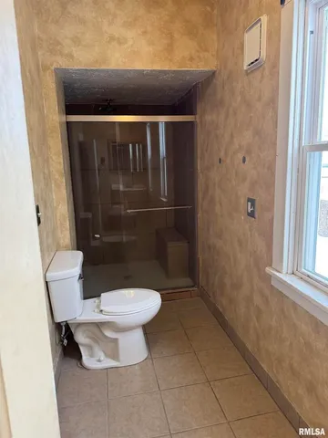 a bathroom with a toilet and a shower