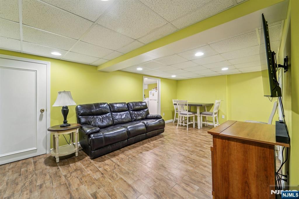 406 Indian Road Wayne, NJ 07470 - Photo 30 of 41 a living room with couches and a flat screen tv with kitchen view