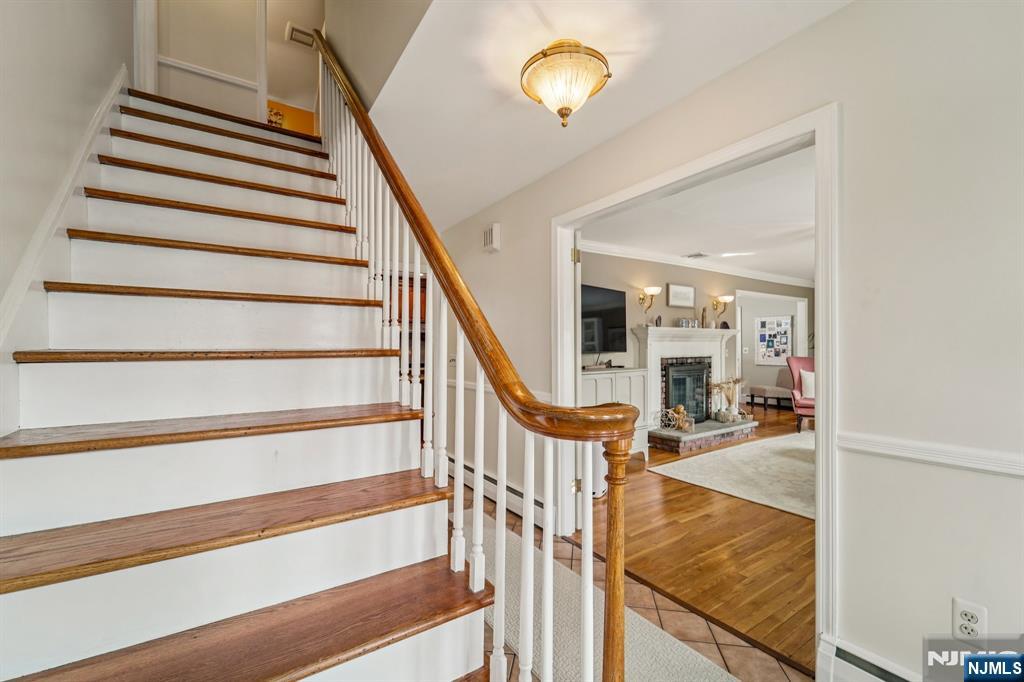 406 Indian Road Wayne, NJ 07470 - Photo 6 of 41 a view of staircase with lots of frames on wall and a chandelier