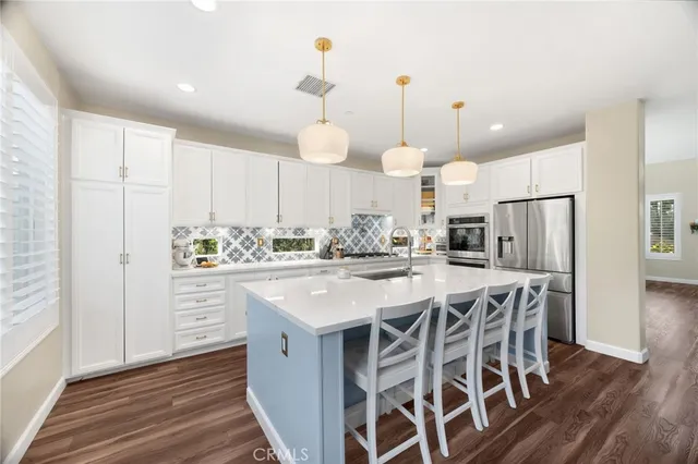 a kitchen with stainless steel appliances granite countertop a sink and a stove