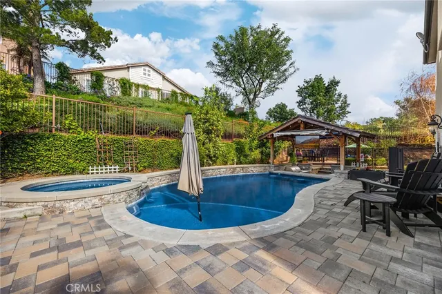 a view of backyard with swimming pool and seating space