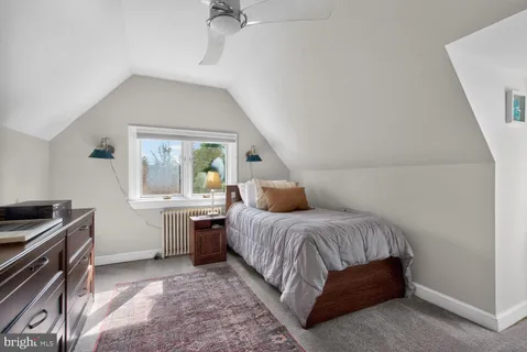 a bedroom with a bed and a large mirror on dresser