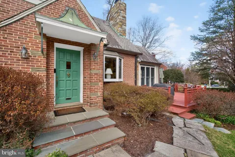 a front view of a house with yard and trees around