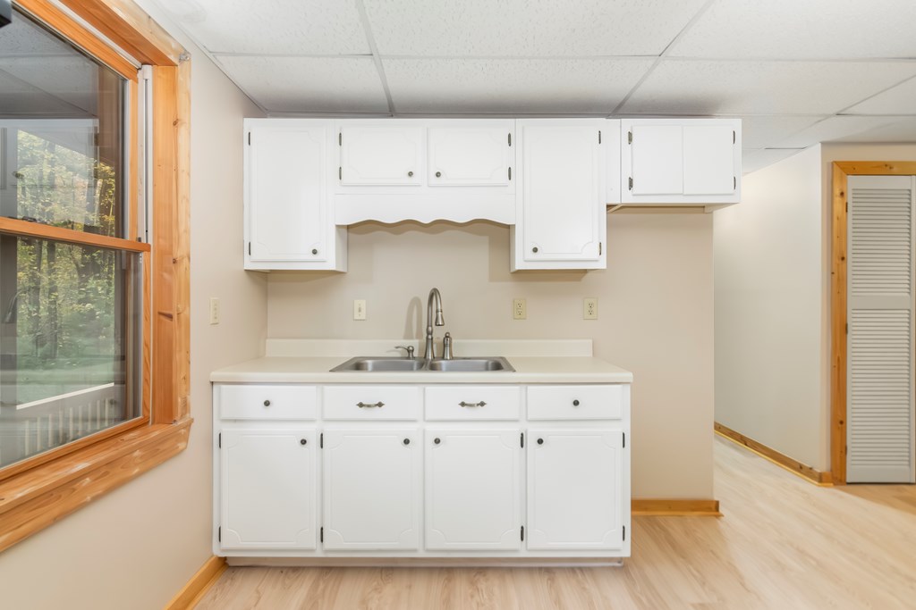 125 Waters Road Ellijay, GA 30536 - Photo 30 of 68 a kitchen with white cabinets and a sink