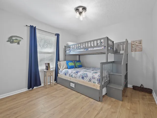 a bedroom with a bed wooden floor and window