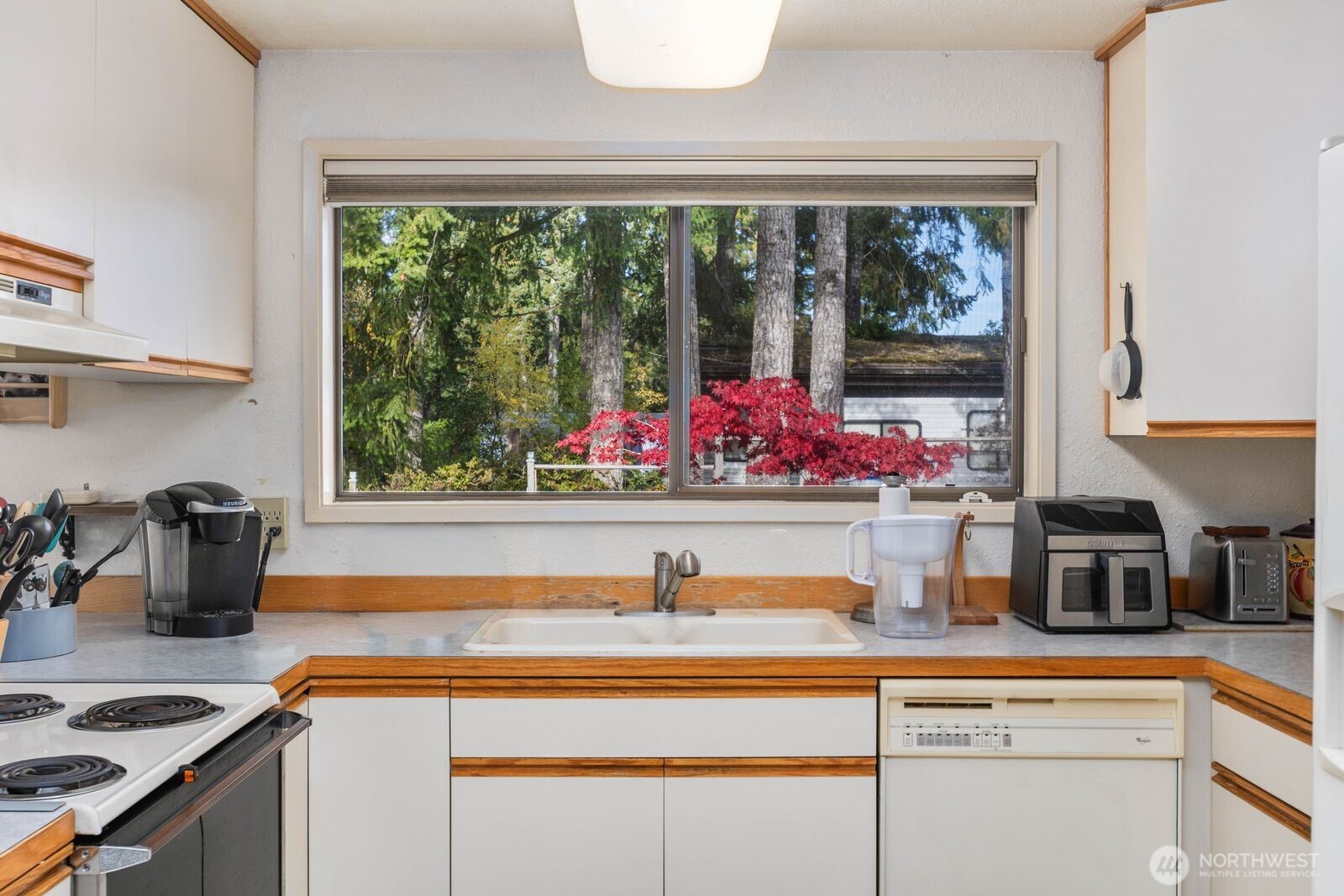 350 East Olympic Drive Grapeview, WA 98546 - Photo 12 of 40 a kitchen with a sink and a stove next to a window