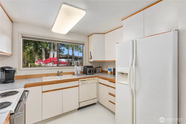 a kitchen with stainless steel appliances white cabinets and a window