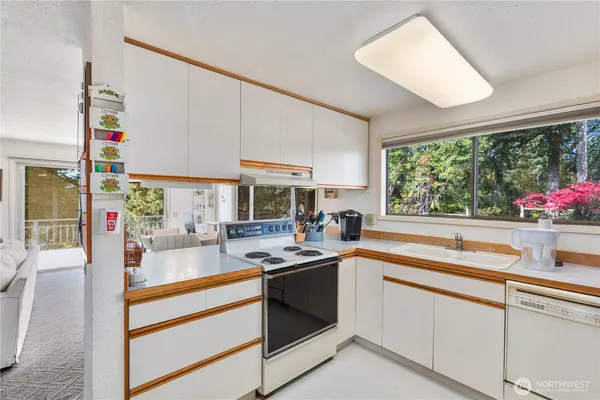 a kitchen with stove a sink and cabinets