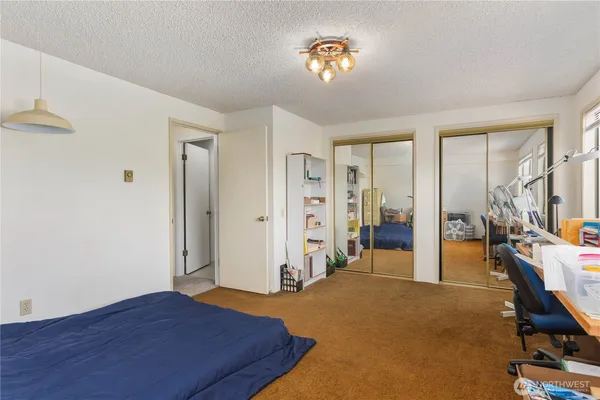 a view of a bedroom with bed and wooden floor