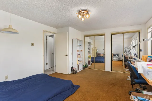 a view of a bedroom with bed and wooden floor