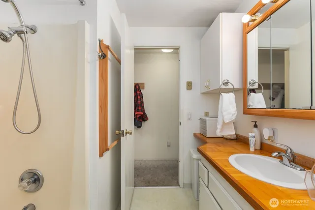 a bathroom with a granite countertop shower a sink and a mirror
