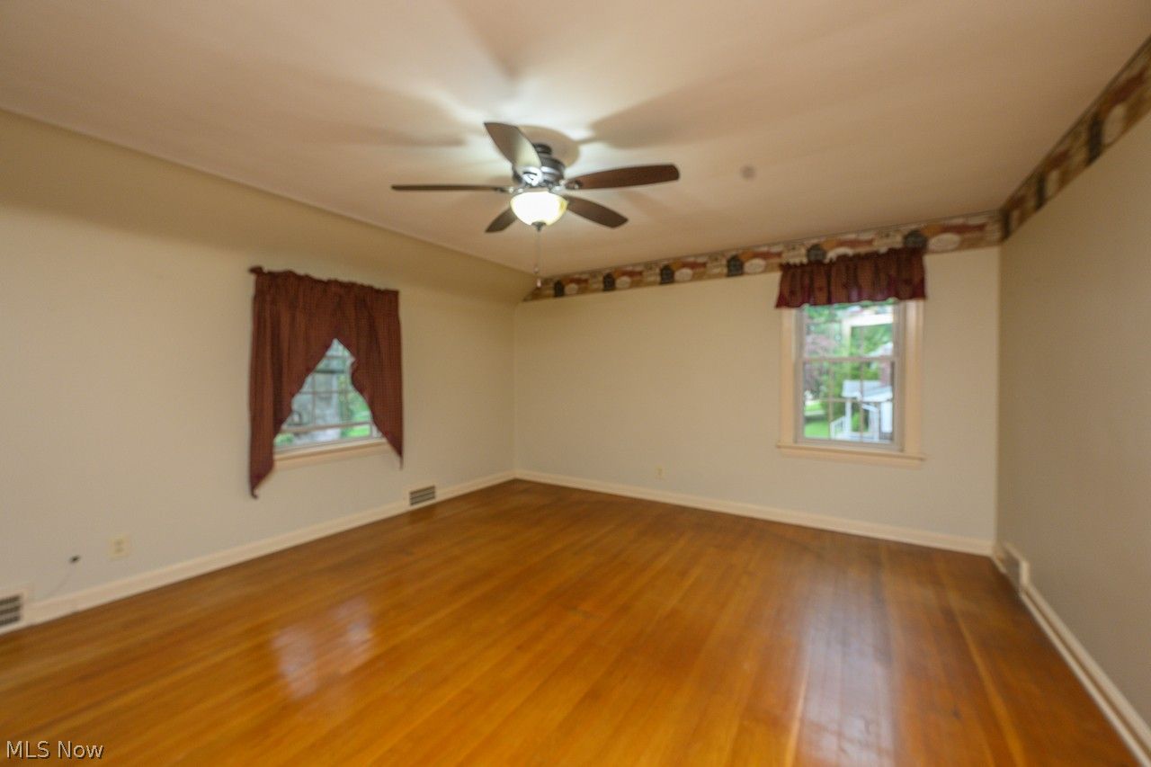 1422 Monument Road Northwest Canton, OH 44703 - Photo 12 of 31 Primary bedroom with multiple windows, ceiling fan and hardwood floors