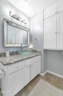 a bathroom with a granite countertop sink and a mirror