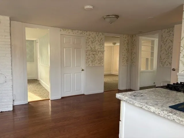 a view of a kitchen that shows a sink kitchen counter and wooden floor