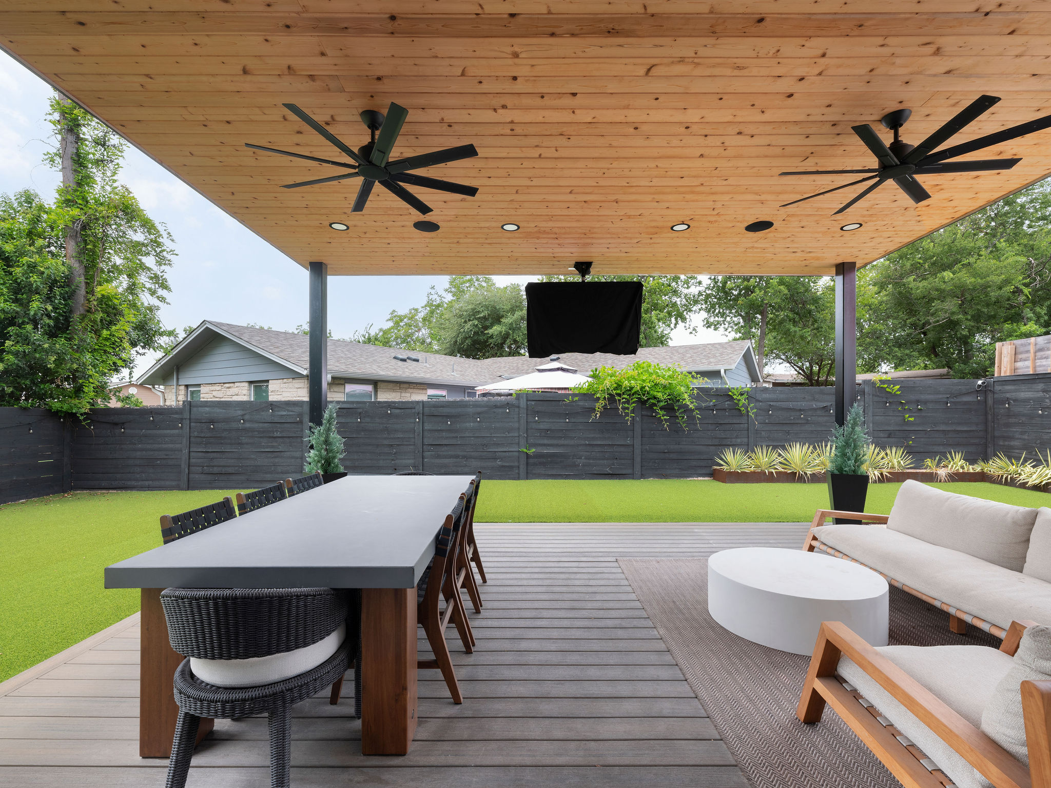 3710 Manorwood Road Austin, TX 78723 - Photo 33 of 40 An inviting outdoor living area features a wooden deck, covered patio, and lush green lawn.