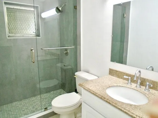 a bathroom with a sink a toilet and shower