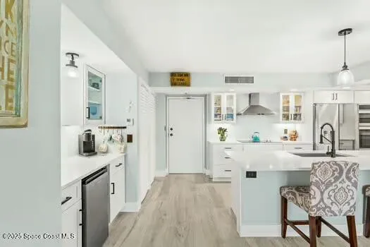 a kitchen with stainless steel appliances white cabinets and wooden floors