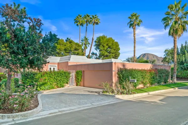 front view of a house with a yard and potted plants
