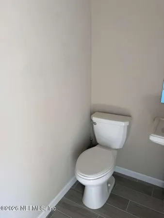 a white toilet sitting next to a white wall