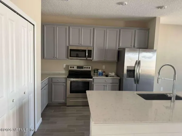 a kitchen with a refrigerator and a stove top oven