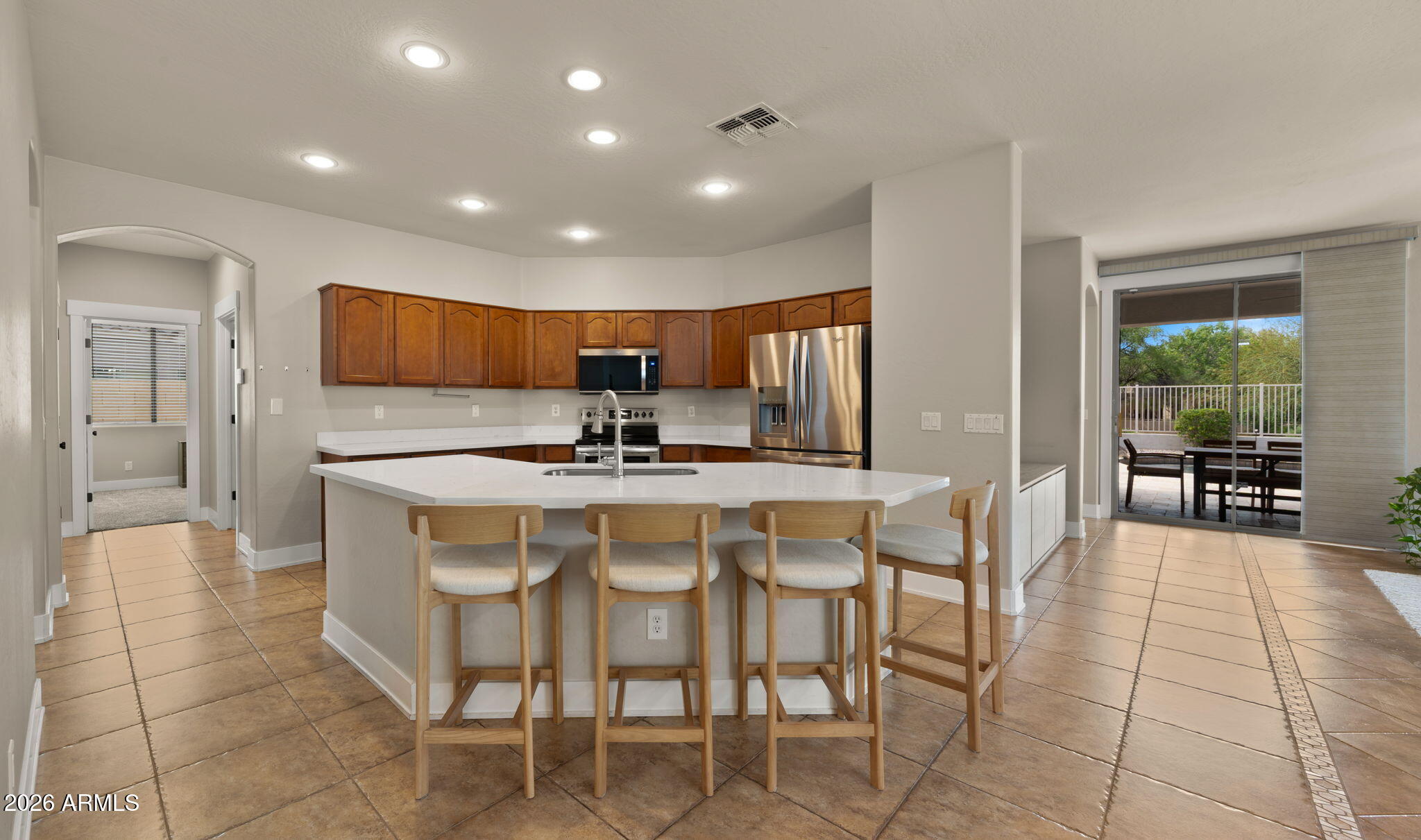 3344 East Hopkins Road Gilbert, AZ 85295 - Photo 6 of 32 a kitchen with stainless steel appliances kitchen island granite countertop a table and chairs