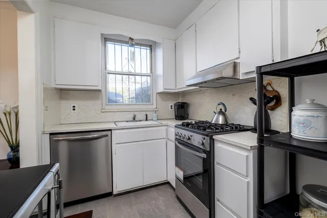 a kitchen with white cabinets and appliances