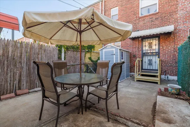 a patio with a table and chairs under an umbrella
