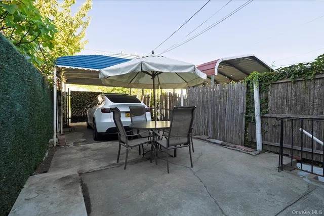 a view of a tables and chairs under an umbrella in backyard