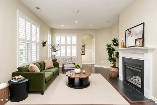 a view of an empty room with wooden floor fireplace and a window