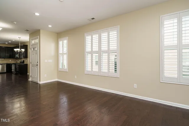 a view of a livingroom with fireplace wooden floor and windows