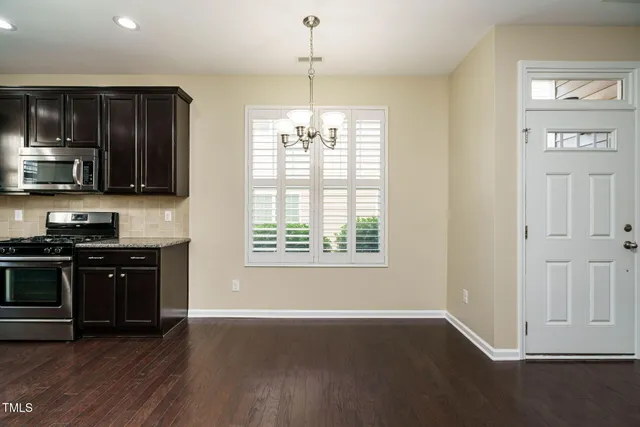 a kitchen with a sink wooden cabinets and stainless steel appliances
