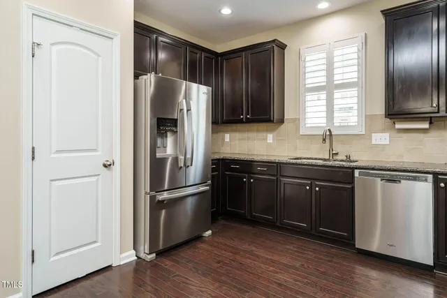 a kitchen with stainless steel appliances granite countertop a stove a sink and a wooden floors
