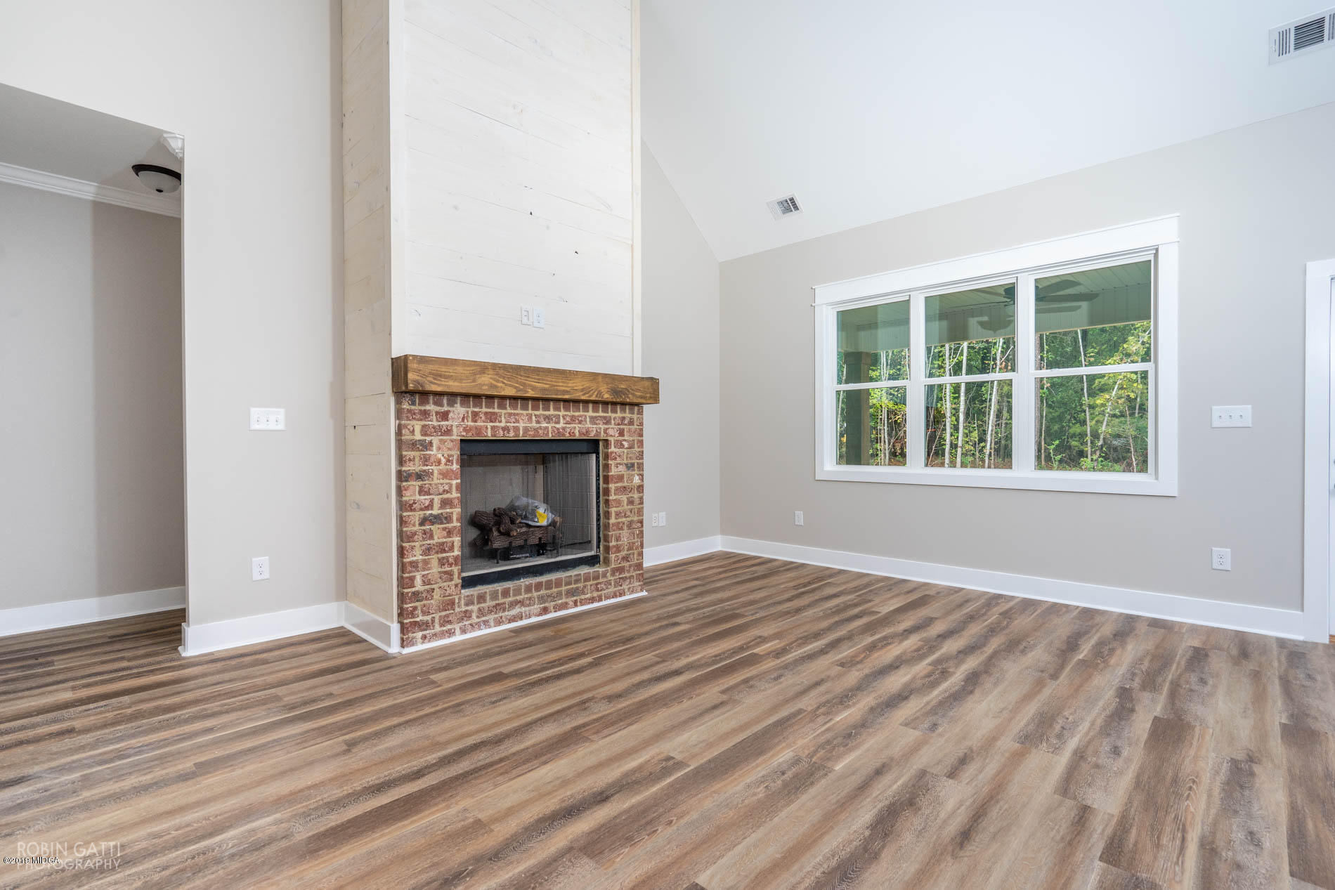 2281 Reedy Creek Road Forsyth, GA 31029 - Photo 8 of 35 an empty room with wooden floor fireplace and windows