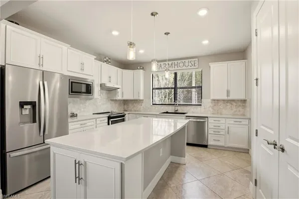 a kitchen with granite countertop white cabinets and a sink