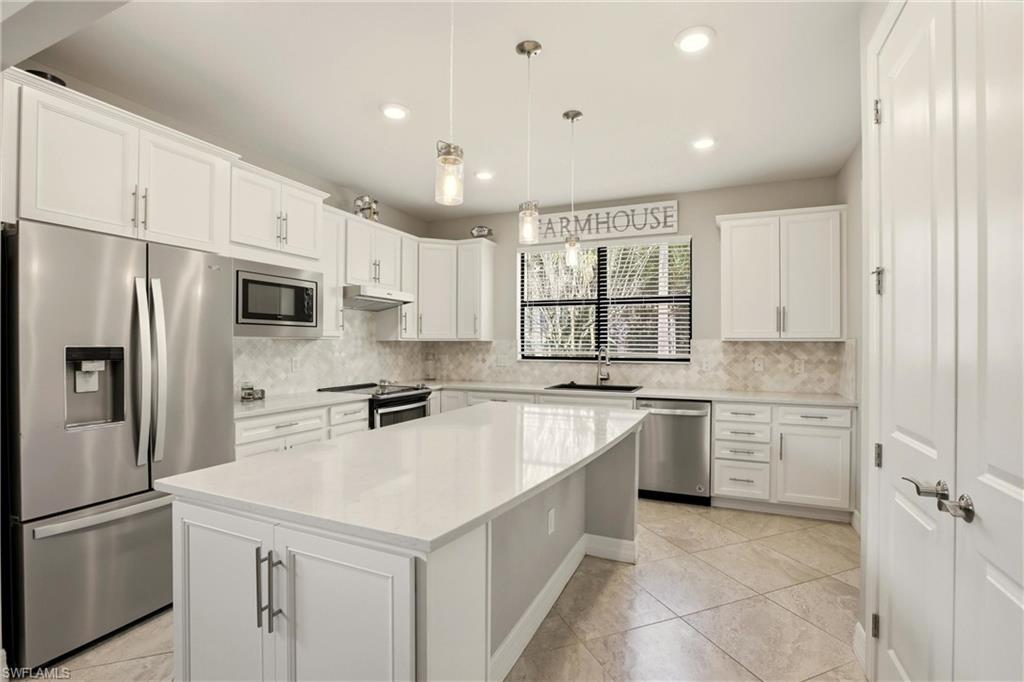 11216 Carlingford Road Fort Myers, FL 33913 - Photo 11 of 38 a kitchen with a refrigerator a sink dishwasher a stove and white cabinets