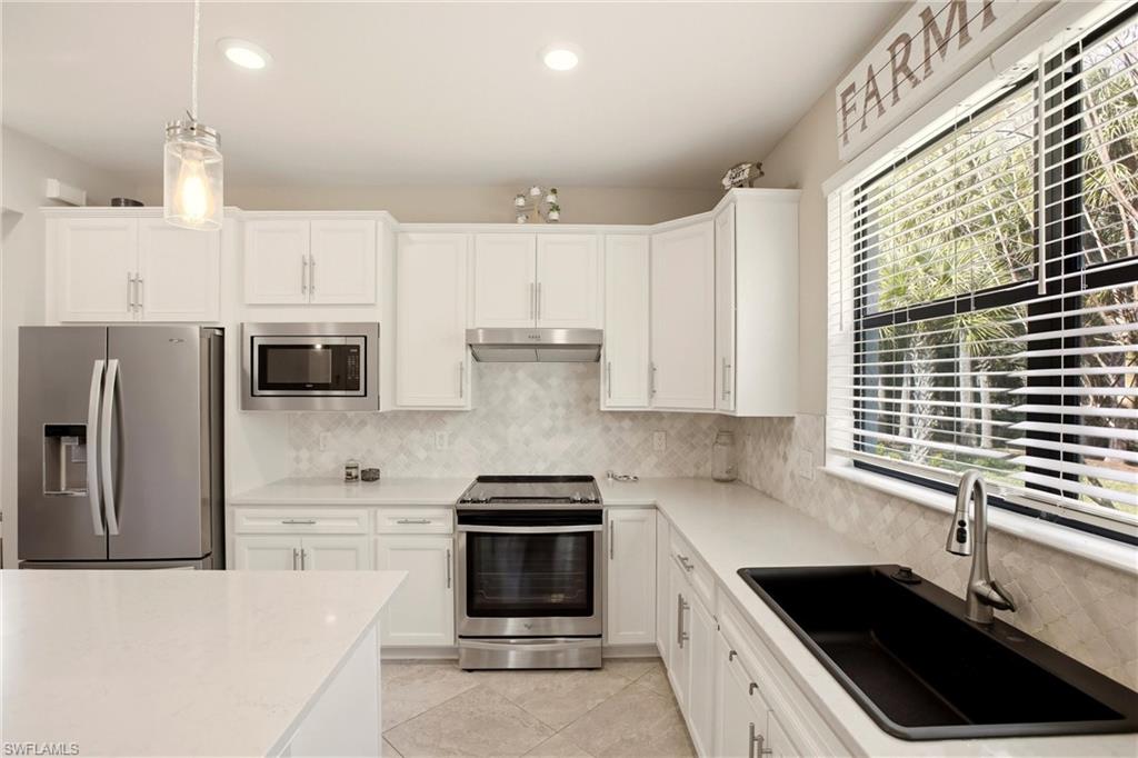11216 Carlingford Road Fort Myers, FL 33913 - Photo 13 of 38 a kitchen with stainless steel appliances granite countertop a sink and a stove