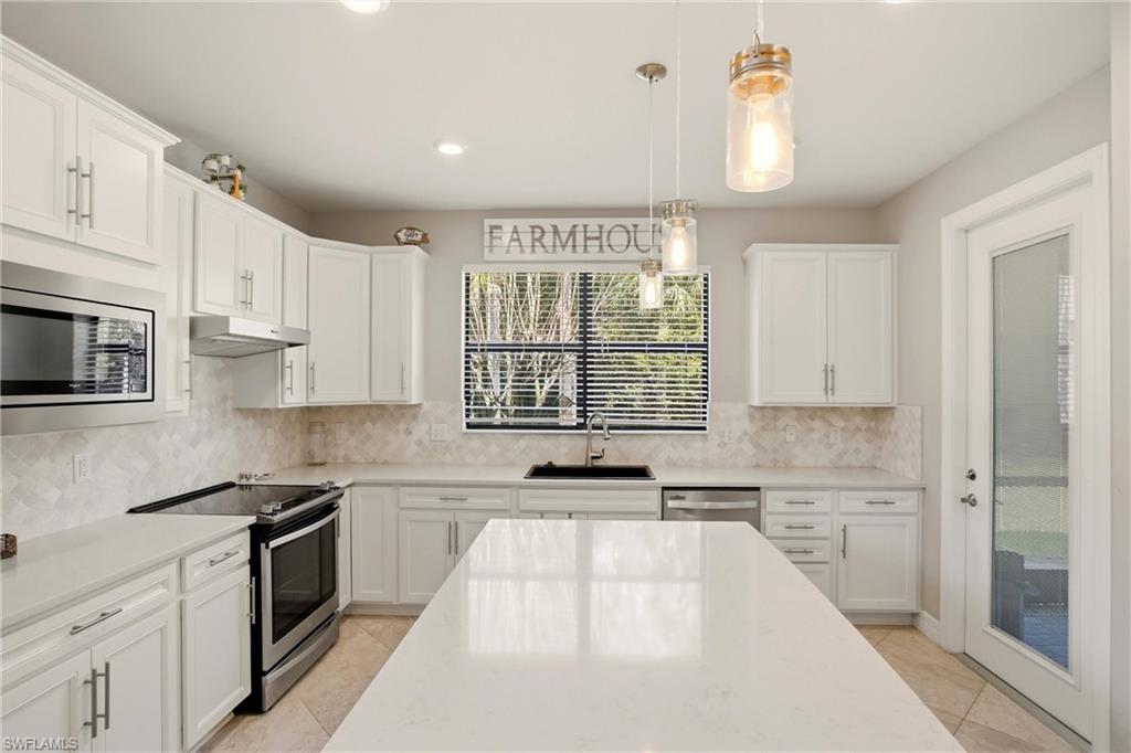 11216 Carlingford Road Fort Myers, FL 33913 - Photo 15 of 38 a kitchen with stainless steel appliances a stove a sink and a microwave