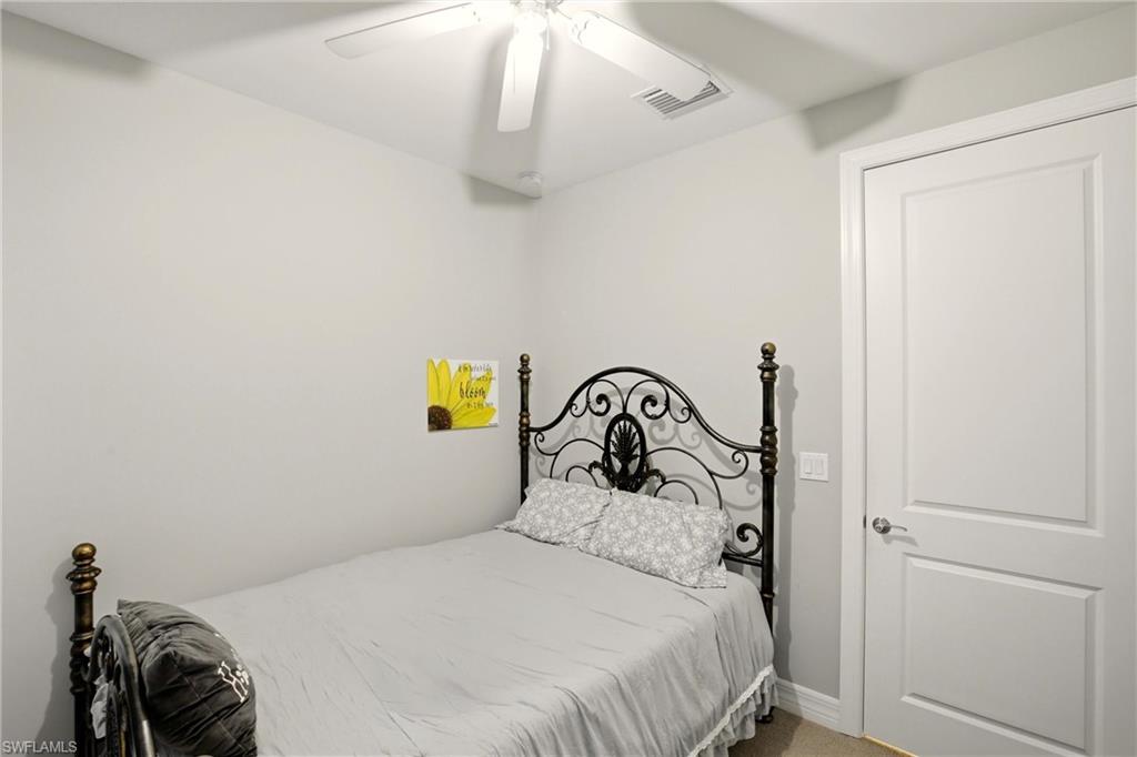 11216 Carlingford Road Fort Myers, FL 33913 - Photo 26 of 38 a bedroom with a bed and a chandelier