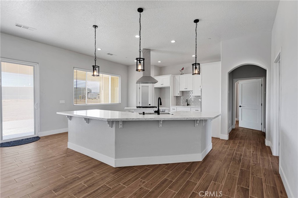 10055 Eaby Road Phelan, CA 92371 - Photo 7 of 19 a kitchen with stainless steel appliances granite countertop wooden floors sink and cabinets