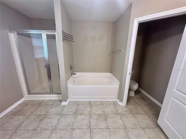 a spacious bathroom with a bathtub sink and mirror