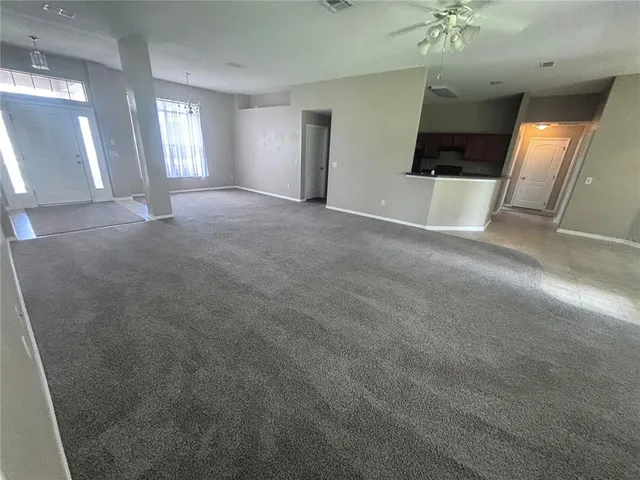 en empty room with windows and fireplace