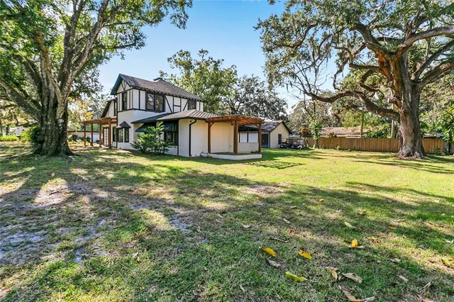 a front view of a house with a yard and trees