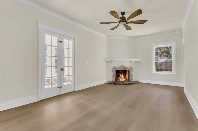 a view of an empty room with a window and fireplace