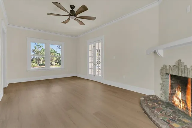 an empty room with windows and ceiling fan